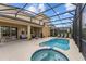 Lovely outdoor living space with pool, hot tub, patio seating, and screened enclosure at 7630 Oakmoss Loop, Davenport, FL 33837
