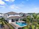 Stunning backyard with a sparkling pool, lounge chairs, covered patio, and lush landscaping at 7702 Fairfax Dr, Kissimmee, FL 34747