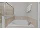 Bathroom featuring a bathtub, shower, and neutral tile surround at 7702 Fairfax Dr, Kissimmee, FL 34747