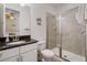 Well-lit bathroom featuring a single vanity with a granite countertop and a glass-enclosed shower, providing a clean and functional space at 7702 Fairfax Dr, Kissimmee, FL 34747