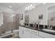 Bright bathroom boasts double sinks, granite counters, and tiled shower with glass doors at 7702 Fairfax Dr, Kissimmee, FL 34747
