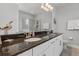 Elegant bathroom featuring a double vanity, granite countertops, and a spacious mirror at 7702 Fairfax Dr, Kissimmee, FL 34747