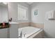 Relaxing bathroom featuring a soaking tub with tile surround and a window with natural light at 7702 Fairfax Dr, Kissimmee, FL 34747