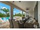 Relaxing covered patio features comfortable wicker seating, a ceiling fan, and views of the sparkling swimming pool and well-maintained landscaping at 7702 Fairfax Dr, Kissimmee, FL 34747