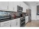 Modern kitchen with stainless steel appliances, granite countertops, and stylish tile backsplash at 7702 Fairfax Dr, Kissimmee, FL 34747