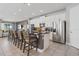 Open-concept kitchen with granite countertops, stainless steel appliances, a breakfast bar, and white cabinets at 7702 Fairfax Dr, Kissimmee, FL 34747