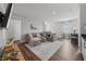Bright living room featuring a large gray sectional, wood floors, and neutral décor at 7702 Fairfax Dr, Kissimmee, FL 34747