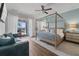 Spacious main bedroom with a four-poster bed, wood floors, and a sliding glass door to the patio for seamless indoor-outdoor living at 7702 Fairfax Dr, Kissimmee, FL 34747