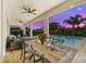 This covered patio features an outdoor dining area and views of the private swimming pool at 7702 Fairfax Dr, Kissimmee, FL 34747