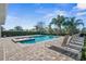 Scenic backyard pool and spa with palm trees and lounge chairs at 7702 Fairfax Dr, Kissimmee, FL 34747