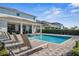 Backyard pool and spa with lounge chairs and lush landscaping at 7702 Fairfax Dr, Kissimmee, FL 34747