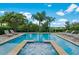 Sparkling pool with lounge chairs and jacuzzi surrounded by lush landscaping at 7702 Fairfax Dr, Kissimmee, FL 34747