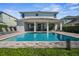 Relaxing backyard pool with a spa, lounge chairs, and privacy hedge at 7702 Fairfax Dr, Kissimmee, FL 34747