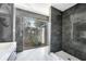 Modern bathroom featuring marble tile, glass shower, and view of stone accent wall at 812 2Nd St, Altamonte Springs, FL 32701