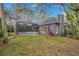 A home's backyard showcasing a screened pool, lush lawn and exterior house features at 827 Royalwood Ln, Oviedo, FL 32765