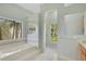 Light and airy bathroom featuring a garden tub, shower, and ample natural light at 827 Royalwood Ln, Oviedo, FL 32765