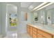 Bright bathroom featuring dual sinks, tiled floor, and a window offering natural light at 827 Royalwood Ln, Oviedo, FL 32765