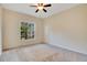 Bright bedroom with a ceiling fan, carpeted floor, and a window view of lush greenery at 827 Royalwood Ln, Oviedo, FL 32765