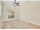 Cozy carpeted bedroom with a ceiling fan and natural light from the window at 827 Royalwood Ln, Oviedo, FL 32765