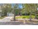Charming single-Gathering home with a well-manicured front yard, large trees, and a two-car garage at 827 Royalwood Ln, Oviedo, FL 32765
