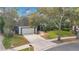 Charming single-Gathering home with a well-manicured front yard, large trees, and a two-car garage at 827 Royalwood Ln, Oviedo, FL 32765
