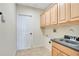 Laundry room features tile floors, overhead cabinets, a sink and access to the garage at 827 Royalwood Ln, Oviedo, FL 32765