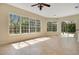 Living room with many windows with a view of trees outside and a door that opens to a screened-in porch at 827 Royalwood Ln, Oviedo, FL 32765