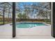 Screened in pool features a spa, a grey concrete deck, and black screen at 827 Royalwood Ln, Oviedo, FL 32765