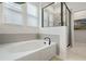 An elegant soaking tub and glass enclosed shower create a luxurious spa-like feel within this pristine primary bathroom at 932 Kylee Aly, Winter Garden, FL 34787