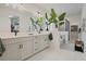 An elegant primary bathroom with double sinks, quartz countertops, and tiled floors. It has an airy and refreshing design at 932 Kylee Aly, Winter Garden, FL 34787