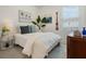 This bedroom is tastefully decorated with beachy artwork, a white comforter, and light from the window at 932 Kylee Aly, Winter Garden, FL 34787