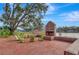 Outdoor fireplace with patio and green chairs overlooking the lake, creating a cozy gathering spot at 932 Kylee Aly, Winter Garden, FL 34787