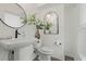 Stylish powder room with pedestal sink, modern fixtures, and decorative mirrors at 932 Kylee Aly, Winter Garden, FL 34787