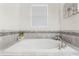 Luxurious bathroom boasts a large soaking tub with decorative tiling and modern faucet at 10267 Authors Way, Orlando, FL 32832