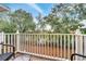 Cozy balcony with patio furniture and a scenic view of the surrounding trees and blue sky at 1027 Park Ridge Cir, Kissimmee, FL 34746