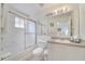 Bright bathroom featuring a shower-tub combo, a large mirror and white cabinets at 1027 Park Ridge Cir, Kissimmee, FL 34746