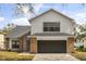 Two-story home showcasing neutral siding, brick accents, attached garage, and manicured front lawn at 1063 Eagles Forrest, Apopka, FL 32712