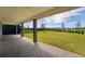 Covered back porch with a brick patio, overlooking a lush green lawn at 11206 Pixie Mandarin Ct, Winter Garden, FL 34787