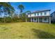 Large backyard featuring lush lawn, mature trees, and the home's exterior at 11206 Pixie Mandarin Ct, Winter Garden, FL 34787