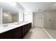 Spacious bathroom with double vanities, a glass-enclosed shower, and neutral tile at 11206 Pixie Mandarin Ct, Winter Garden, FL 34787