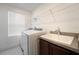 Bright laundry room featuring a utility sink, modern washer and dryer, and convenient shelving at 11206 Pixie Mandarin Ct, Winter Garden, FL 34787