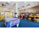 Bright game room with classic arcade games, air hockey, and prize machines on blue carpet at 12521 Floridays Resort Dr # 307F, Orlando, FL 32821