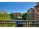 Balcony view of a community lagoon and pool area with blue skies and surrounding foliage at 12521 Floridays Resort Dr # 307F, Orlando, FL 32821