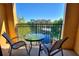 Balcony view of a community lagoon and pool area with blue skies and patio furniture at 12521 Floridays Resort Dr # 307F, Orlando, FL 32821