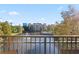 Balcony view of a community lagoon and pool area with blue skies and patio furniture at 12521 Floridays Resort Dr # 307F, Orlando, FL 32821