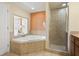 Bathroom featuring a jacuzzi tub, stand up shower, and peekaboo window into the bedroom at 12521 Floridays Resort Dr # 307F, Orlando, FL 32821