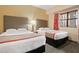 The bedroom features two beds, a large window, and neutral color palette at 12521 Floridays Resort Dr # 307F, Orlando, FL 32821