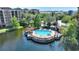 Aerial view of a gazebo covered community pool area in a lagoon surrounded by trees and landscaping at 12521 Floridays Resort Dr # 307F, Orlando, FL 32821