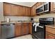 This kitchen features stainless steel appliances, granite countertops, wooden cabinets, and tile floors at 12521 Floridays Resort Dr # 307F, Orlando, FL 32821