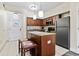 Well-equipped kitchen features wooden cabinetry, an island with seating, and stainless steel appliances at 12521 Floridays Resort Dr # 307F, Orlando, FL 32821
